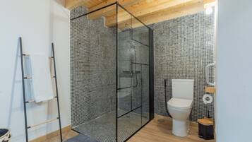 A modern bathroom with a shower enclosure, toilet, and a towel rack.