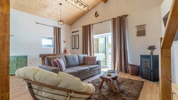 A cozy living room with a sofa, a chair, a coffee table, and a fireplace.