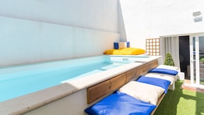 A swimming pool with a wooden deck and lounge chairs. - Casa São José (Carvalhal)