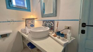 A bathroom with a white sink, a mirror, a towel rack, and a window with a view. - Villa Calisto - San Pantaleo (Olbia)