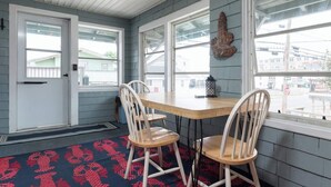 A room with a wooden table and two chairs, a patterned rug, and a decorative wall hanging. - Lovely- 3 Bedroom apt in Vaca Beach home (Hampton)