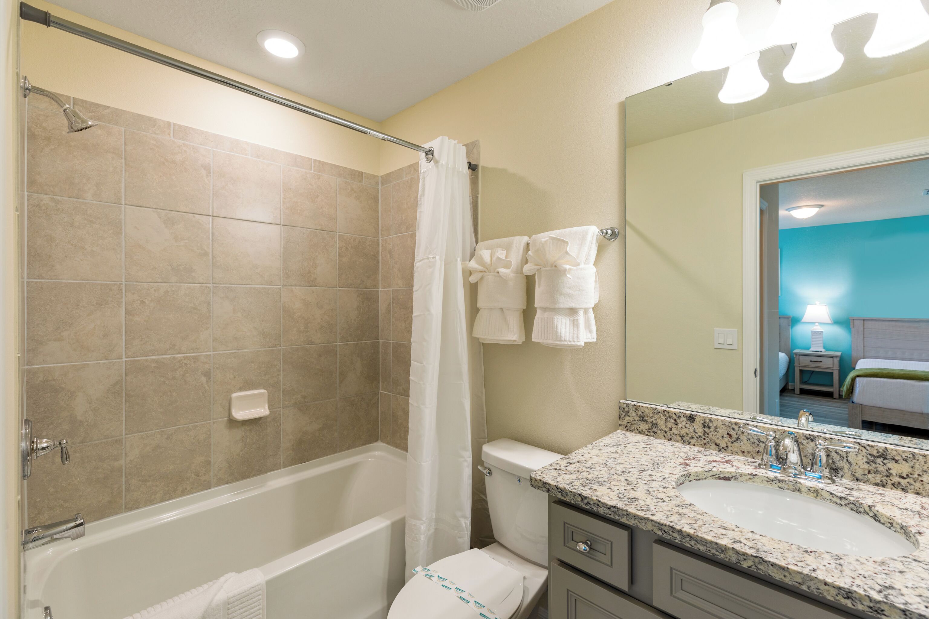 A bathroom with a bathtub, shower, toilet, and a sink with a mirror.