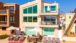 A beachfront hotel with multiple balconies, outdoor seating, and a pool area. - Beachfront Villa w/ Direct Beach Access & Elevator!  (Oxnard)
