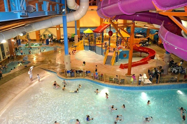 Een overdekt waterpark met glijbanen, zwembaden en speelzones.