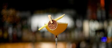 A cocktail with a citrus garnish on a bar counter.