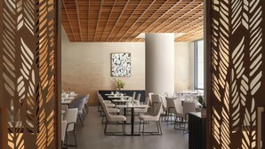 A restaurant interior with a modern design, featuring a wooden ceiling, a central column, and a dining area with tables and chairs. - InterContinental Seattle Bellevue, by IHG (Bellevue)
