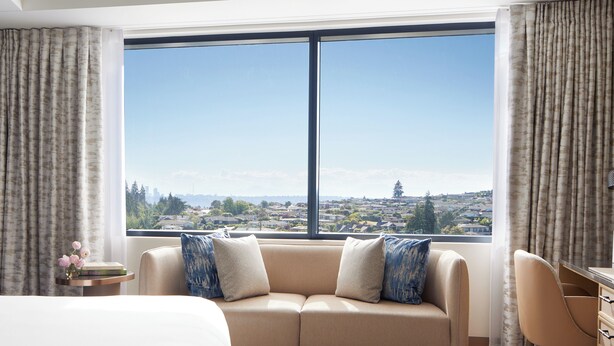 A hotel room with a large window, a sofa, a desk, and a chair. - InterContinental Seattle Bellevue, by IHG (Bellevue)