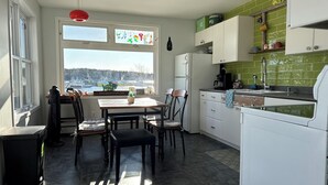 Eine Küche mit Esstisch, Stühlen, einem Kühlschrank und Blick auf den Hafen.