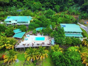 A resort with multiple buildings, a swimming pool, and lush tropical vegetation. - Pinard's Mountain Resort- Cottage 8 (Pointe Michel)