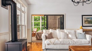 A cozy living room with a fireplace, a white sofa, and a wooden coffee table.