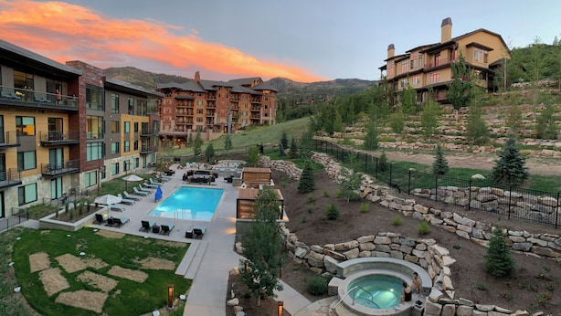 A resort with a swimming pool, hot tub, and outdoor seating area.