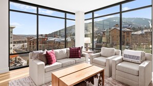 A spacious living room with large windows offering a mountain view.