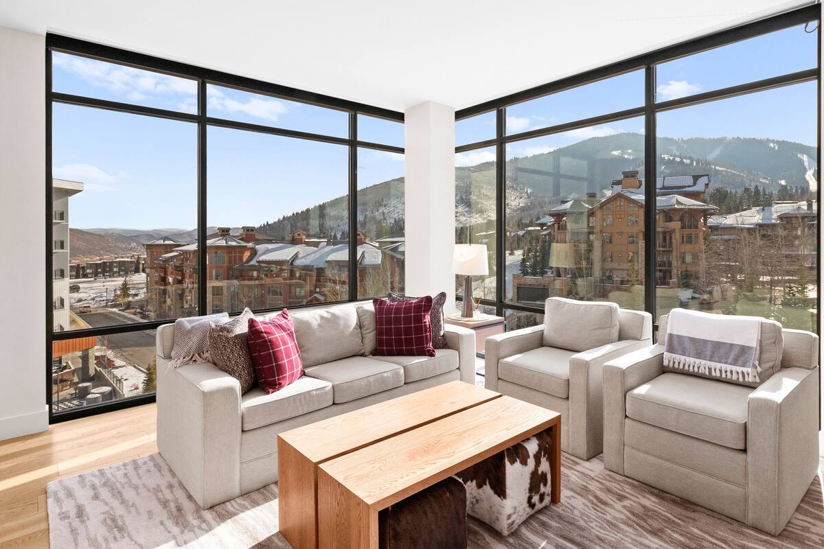 A spacious living room with large windows offering a mountain view.