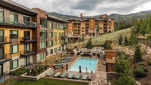 A hotel with a pool area, outdoor seating, and a view of the mountains. - Lift by All Seasons Resort Lodging (Park City)