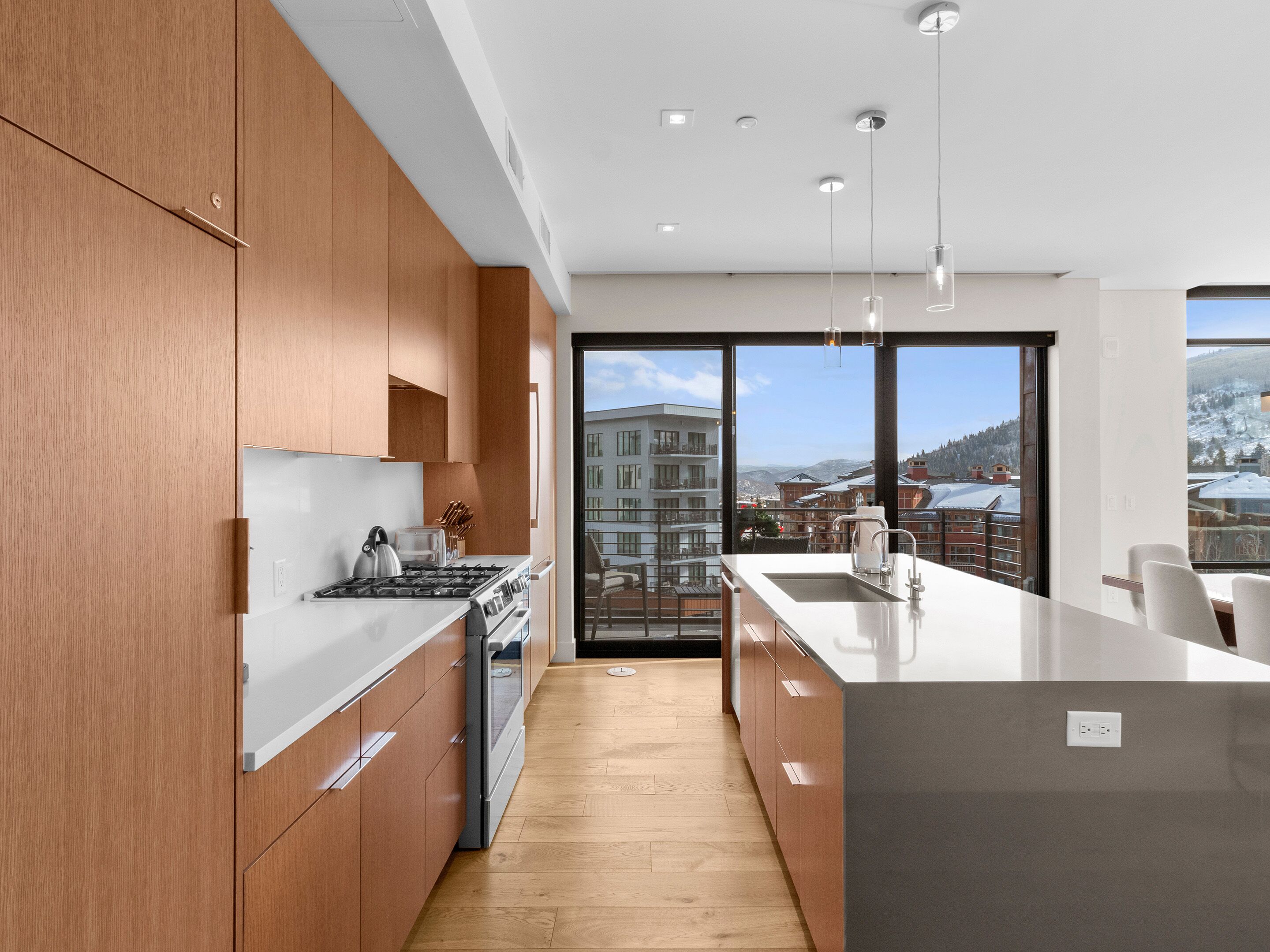 Una cocina moderna con armarios de madera, estufa de acero inoxidable y una isla grande con pileta.