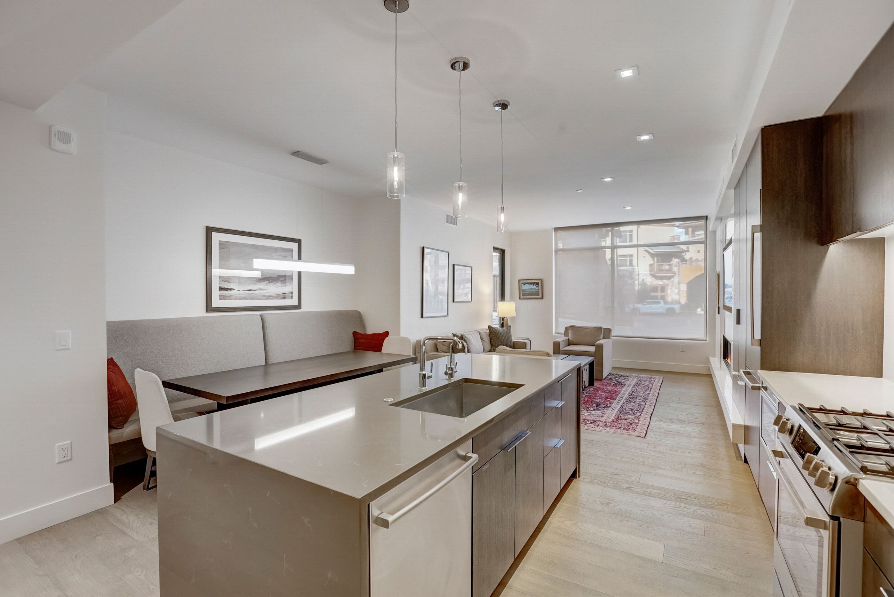 A modern kitchen with a central island, stainless steel appliances, and pendant lighting.