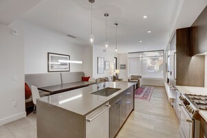 A modern kitchen with a central island, stainless steel appliances, and pendant lighting.