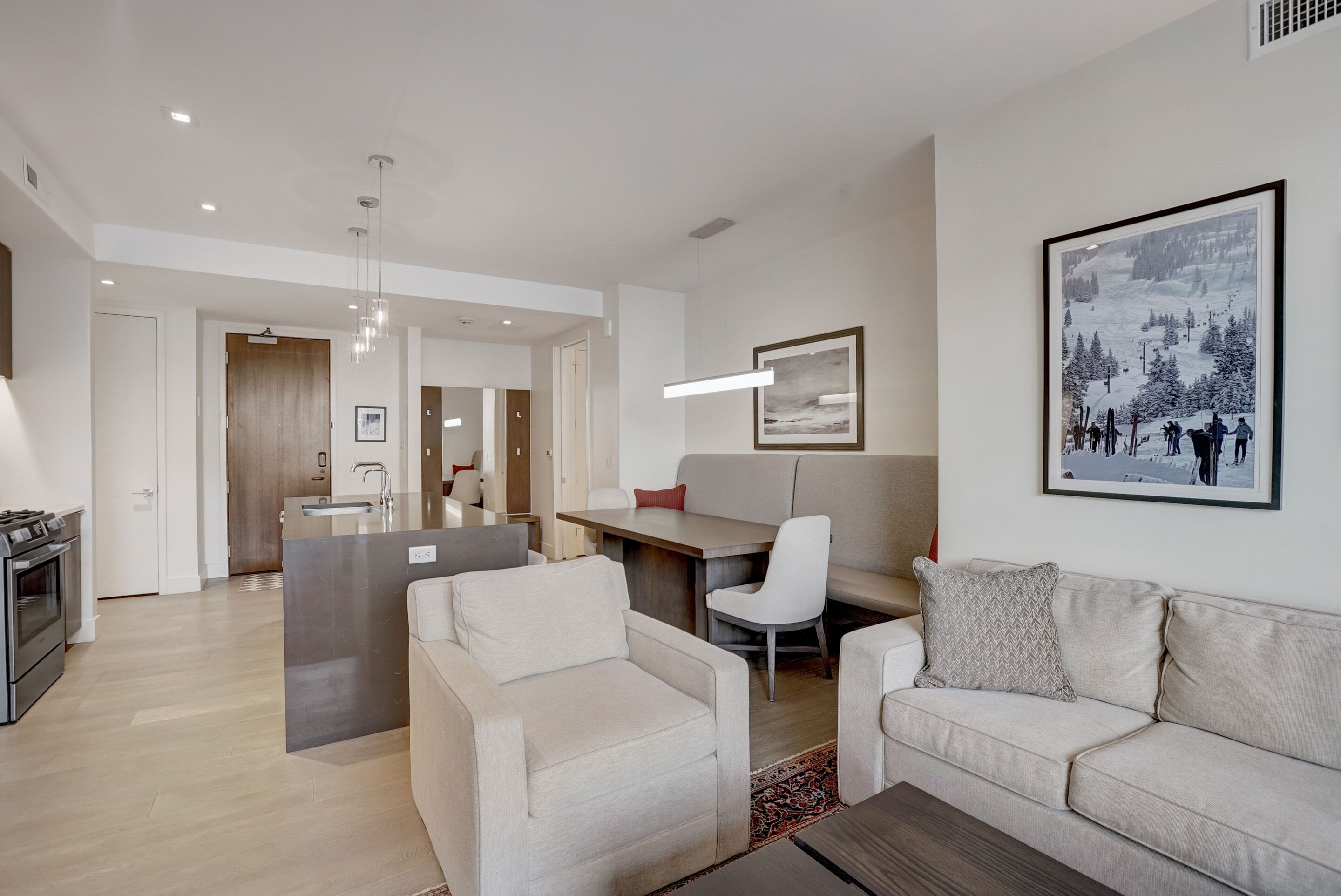 A modern living room with a sofa, a coffee table, and a dining area with a table and chairs.