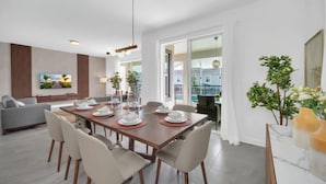 A modern dining area with a wooden table set for six, surrounded by six chairs. - Delight Kangaroo Home by All Vacation (Davenport)