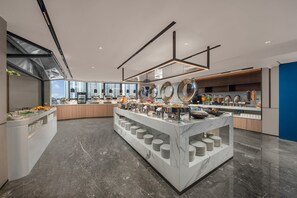 A modern kitchen with marble countertops, a central island with plates, and a view of the city. - Holiday Inn Express Shantou Chenghai by IHG (Shantou)