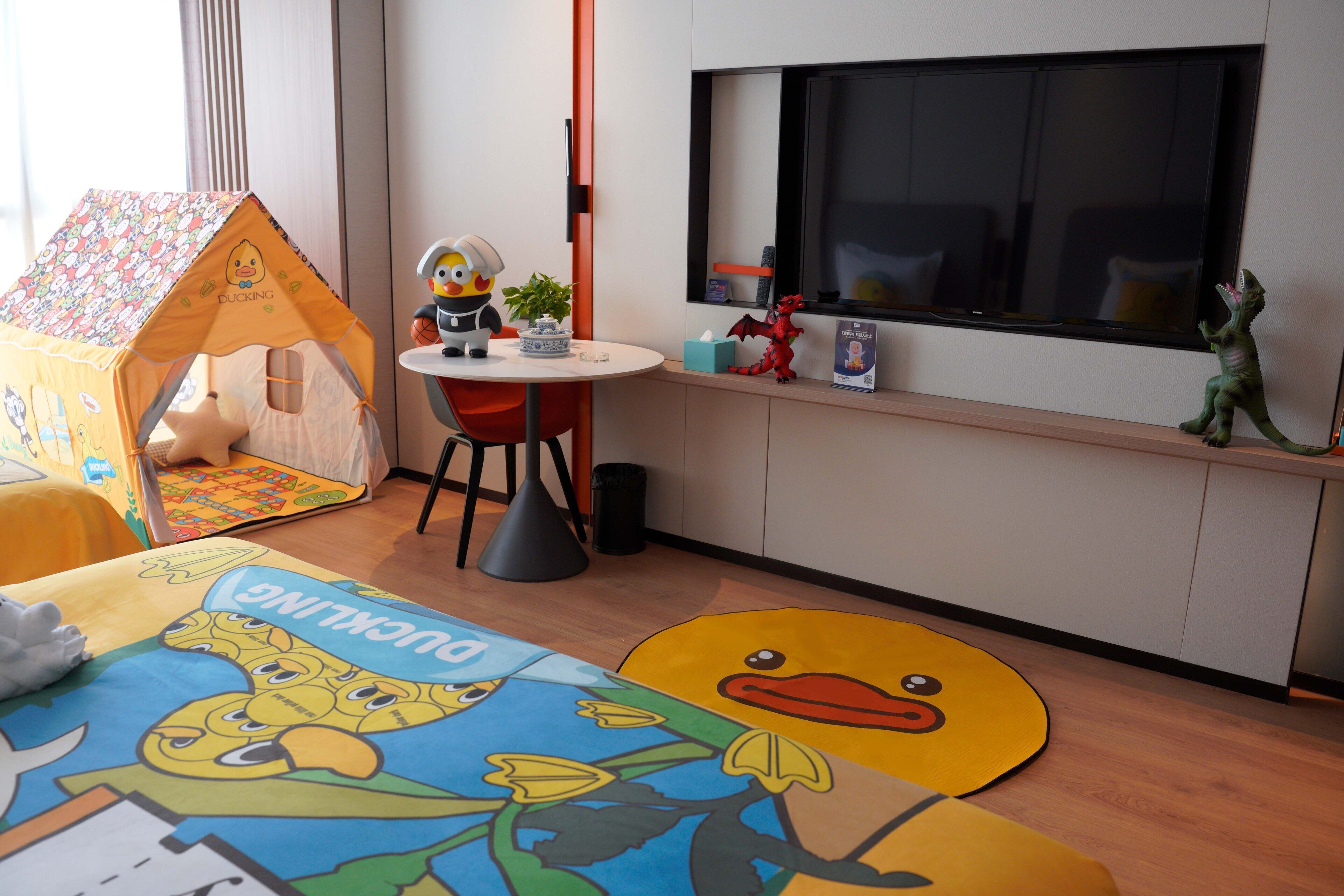 A child's playroom with a play tent, a table with toys, and a large window.