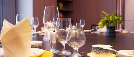 A dining table set with various dishes, glasses, and a plant.