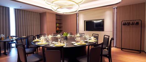A modern dining area with a round table set for a meal, surrounded by chairs.