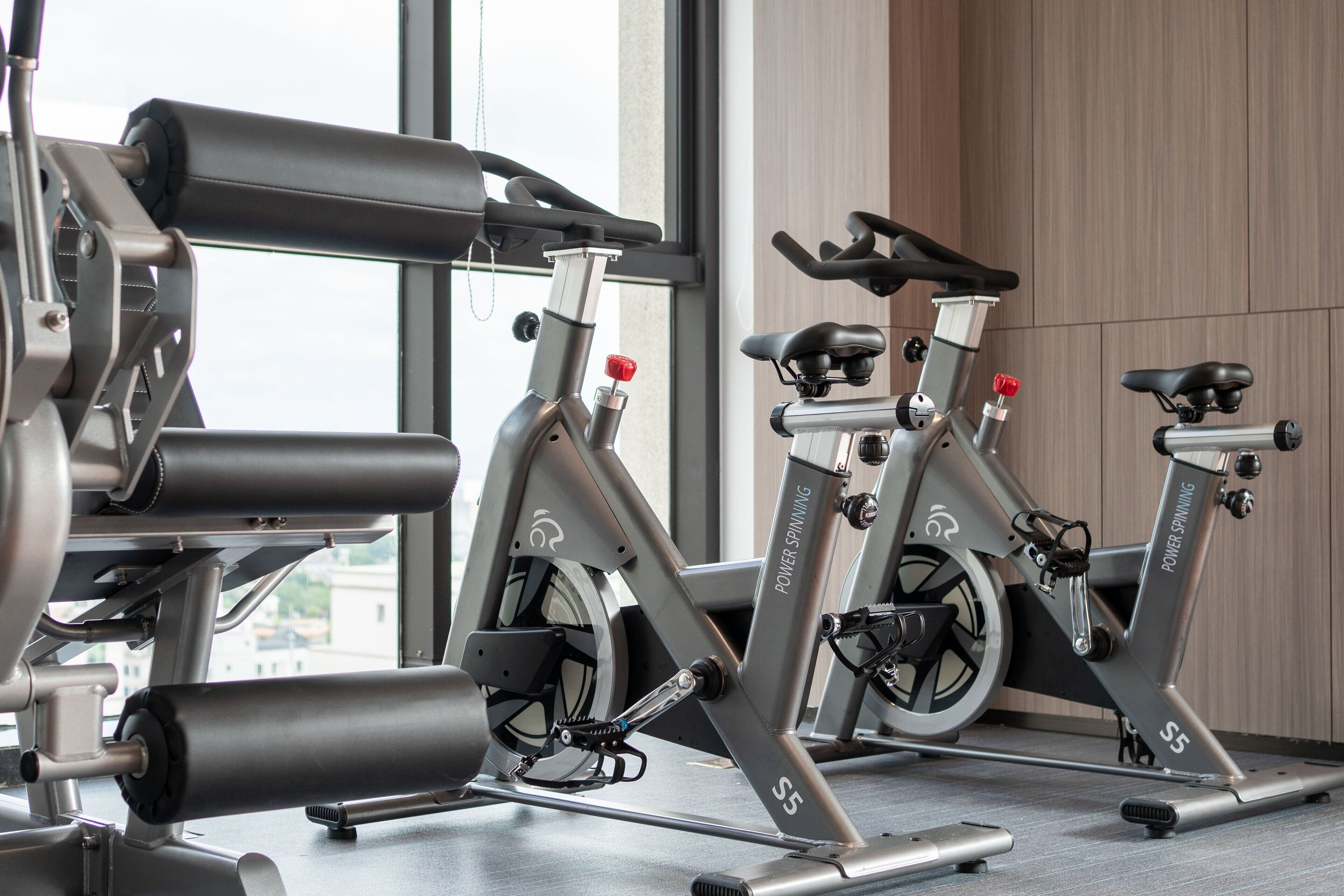 A stationary bike in a gym with a window view.