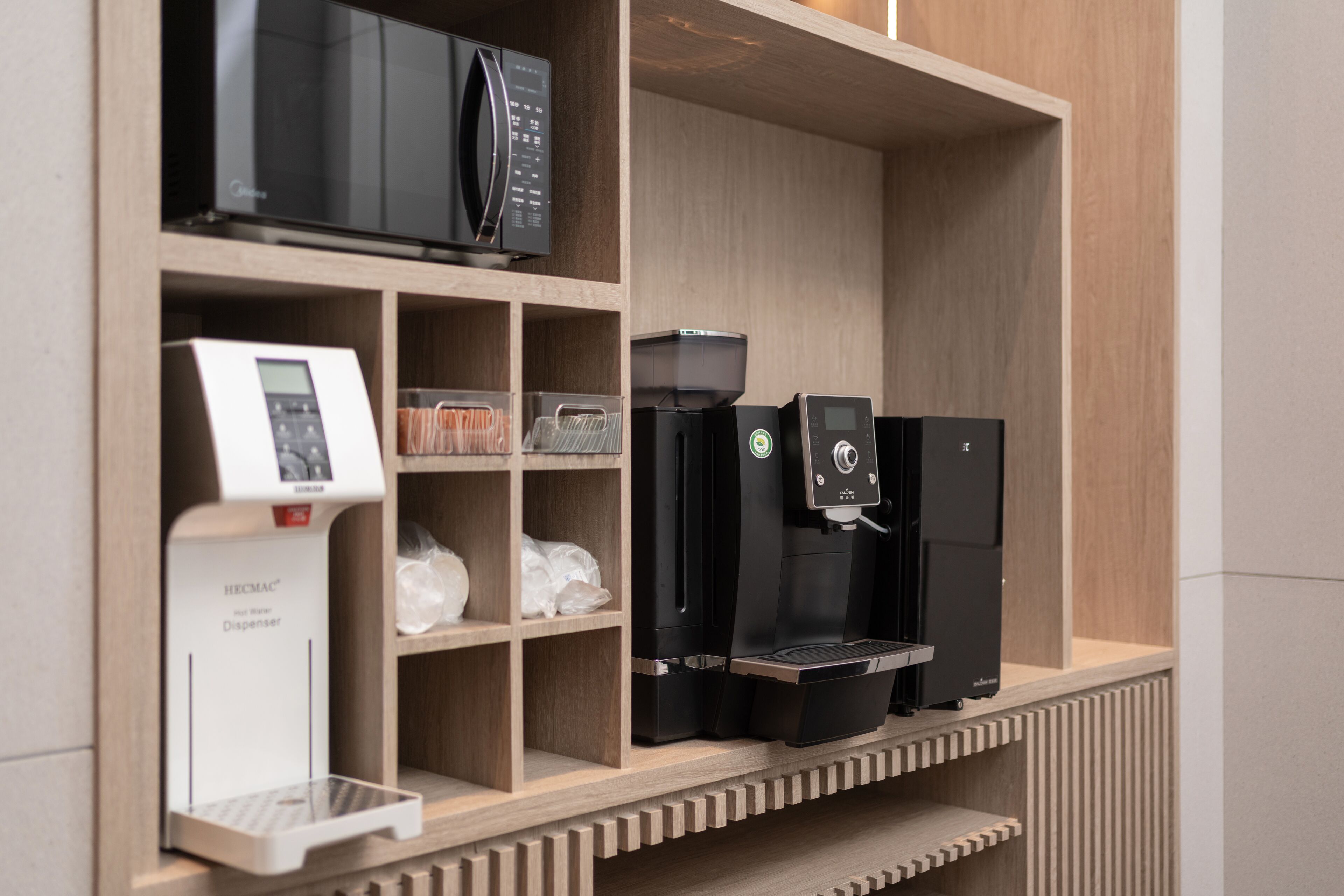 A coffee station with a coffee maker, a water dispenser, and a scale.