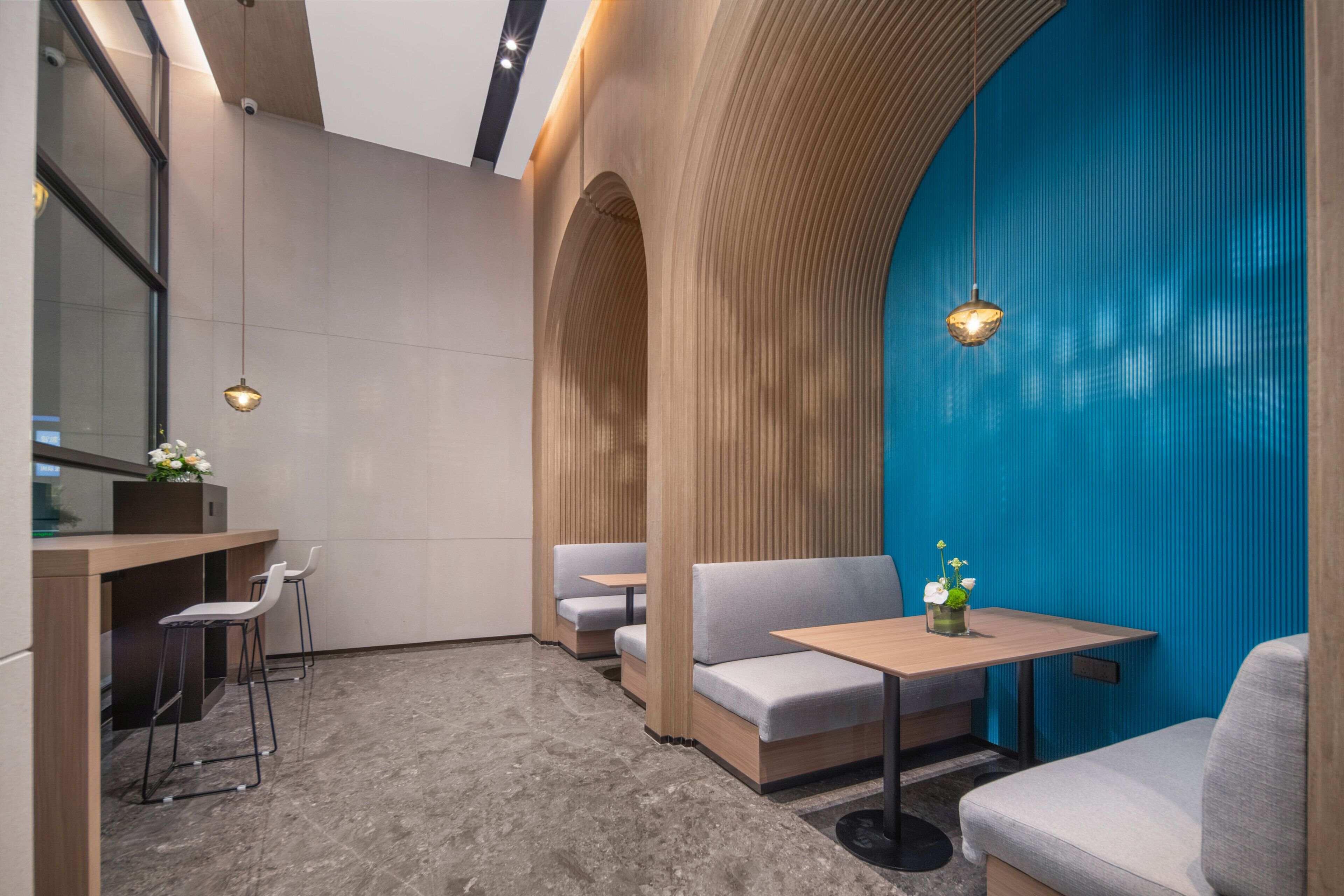 A modern interior with seating areas, a counter, and a blue accent wall.