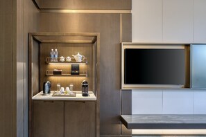 Cozinha moderna com estação de café integrada, TV de tela plana e design de bancada elegante.