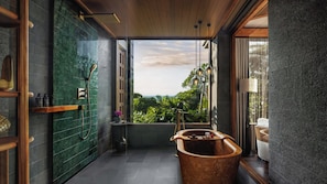 A modern bathroom with a bathtub, shower, and large windows offering a view of greenery. - Regent Bali Canggu (Canggu)