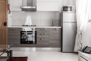 A modern kitchen with a built-in oven, microwave, and refrigerator.