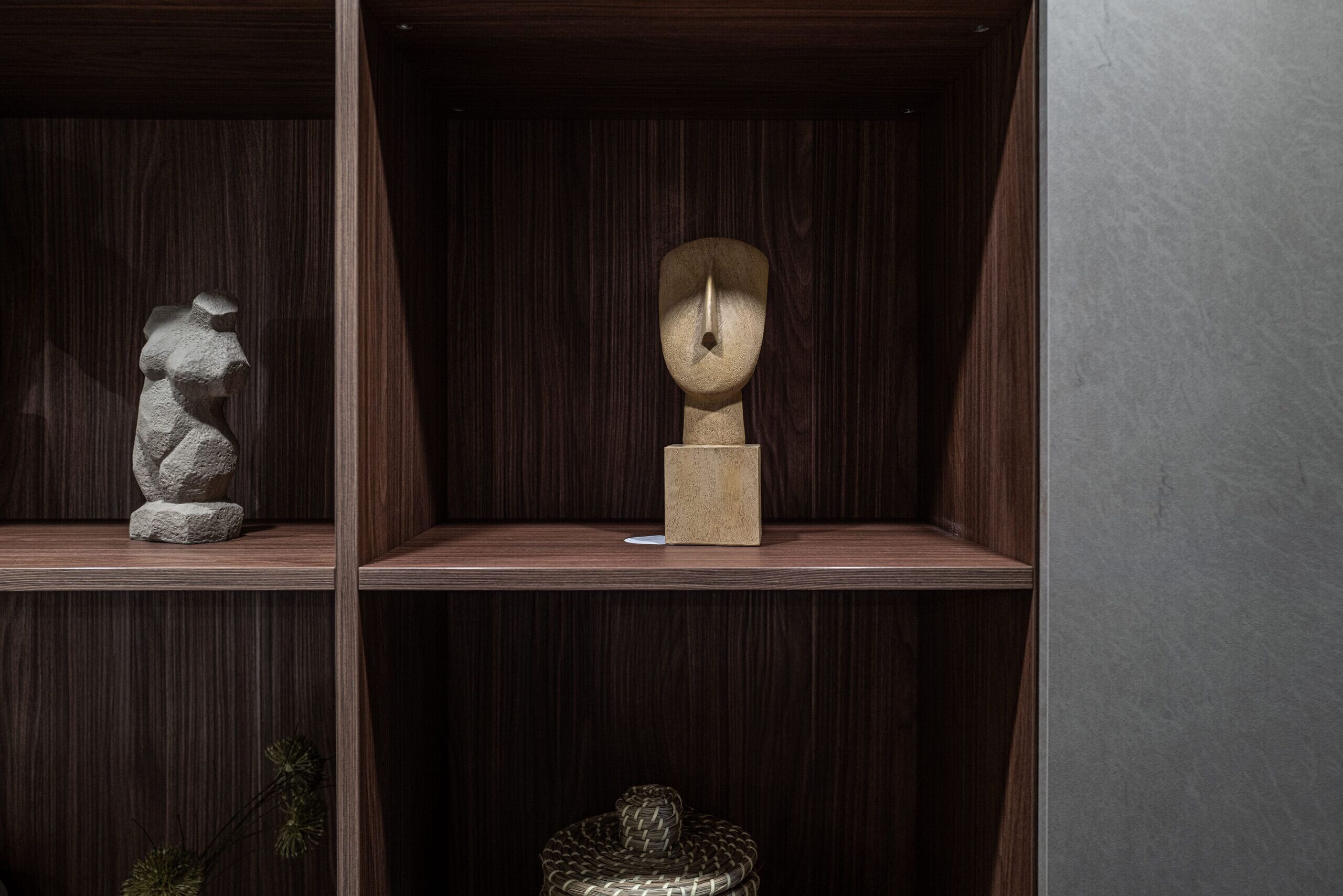 A wooden shelf with three sculptures.