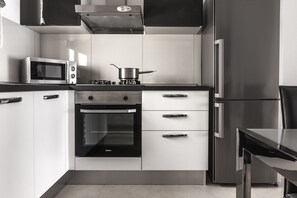 Eine moderne Küche mit Mikrowelle, Herd, Backofen und Kühlschrank.