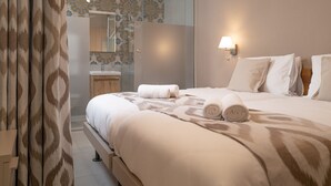 Quarto de hotel com uma cama, banheiro e chuveiro.