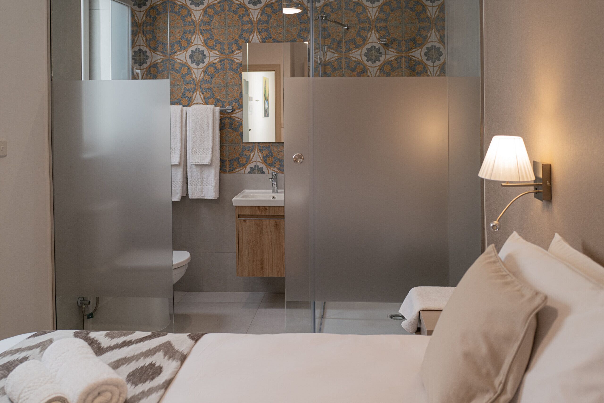 A modern bathroom with a shower, toilet, and sink.