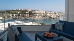 A balcony with a view of a marina and cityscape. - Portside Lodge Building (Marsaskala)
