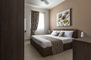 Une chambre Ă coucher avec un lit, des rideaux, une Ćuvre dâart accrochĂ©e au mur, des lampes de chevet et une table de chevet en bois.
