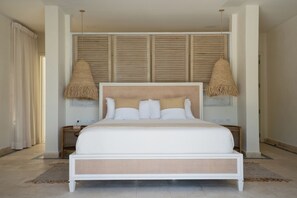 Relax in this serene bedroom with a large bed, wooden headboard, and soft lighting.