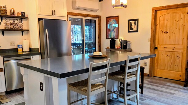 Una cucina moderna con isola centrale, elettrodomestici in acciaio inossidabile e travi in legno al soffitto.