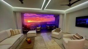 A modern living room with a city view, a flat-screen TV, and ceiling fans. - Soho - PV
Luxury resort condo in heart of town with ocean & city view. (Puerto Vallarta)
