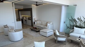 A modern living room with white furniture, a glass partition, and a view of the kitchen. - Soho - PV
Luxury resort condo in heart of town with ocean & city view. (Puerto Vallarta)