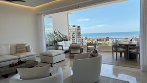 A modern living room with a large window overlooking a cityscape and the sea. - Soho - PV
Luxury resort condo in heart of town with ocean & city view. (Puerto Vallarta)