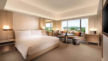 A hotel room with a large bed, a seating area with a table, and a TV.