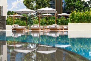 Una piscina al aire libre, camas de piscina gratis, sombrillas