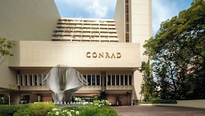 Un bâtiment moderne sur lequel on peut clairement lire l’inscription « CONRAD ».