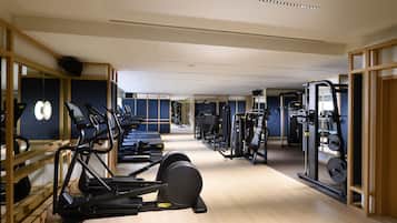 A gym with treadmills, elliptical machines, and weight equipment.