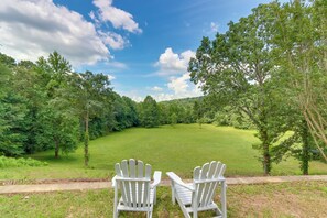 Due poltrone Adirondack rivolte verso un prato verde con alberi sullo sfondo.