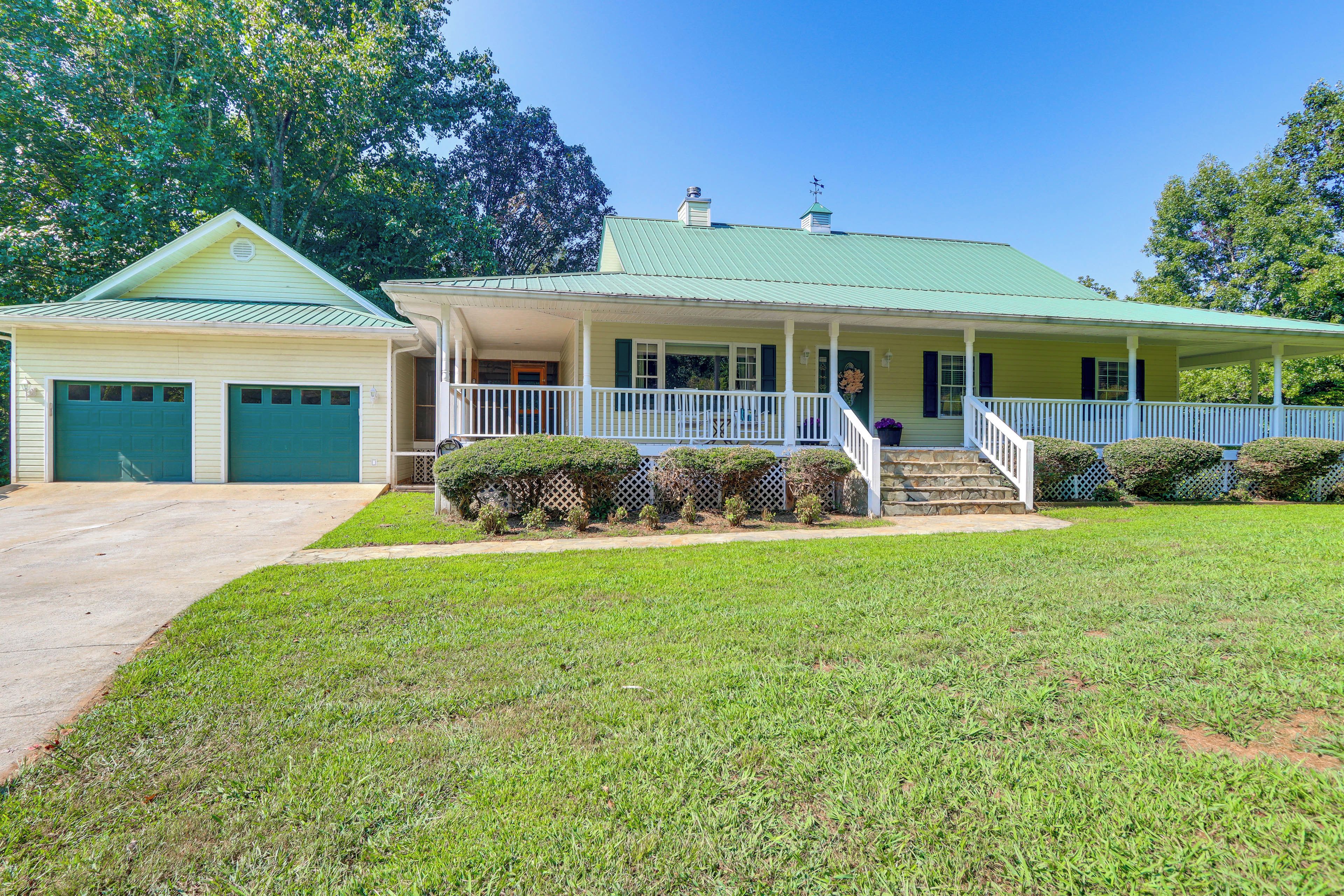 A two-story house with a front porch, a garage, and a well-maintained lawn.